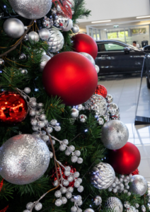Closeup of large Christmas tree in car showroom decorated in red and silver