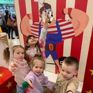 Children standing in front of Strongman Circus photoboard at local shopping centre
