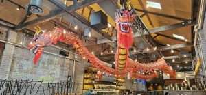 Two enormous red and yellow dragons stretch across the roof of a restaurant