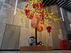 An LED cherry tree lights up a commercial space in Melbourne's CBD. Red discs and lanterns hang from the branches
