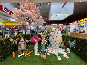 An array of Easter bunnies in a hedged garden make a mess with large white speckled egg, carrots and toad stools