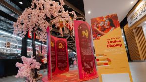 A cherry blossom stands over a Lunar New year zodiac Display - a zodiac calendar around a gazebo structure inside a shopping centre