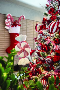 A red and white candy themed decorated Christmas tree with oversize red velvet Christmas stocking filled with Candy at Hyatt Centric Hotel