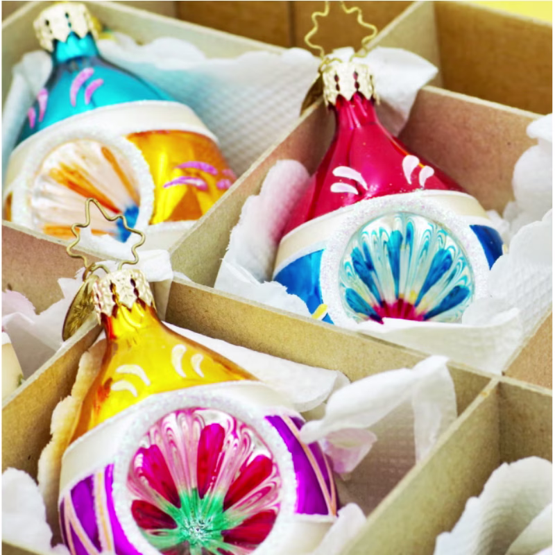 Colourful Vintage shaped and decorated Christmas glass ornaments sitting in a box with tissue