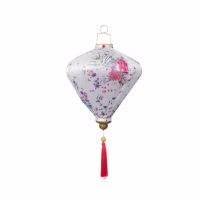 A white fabric floral lantern with decorative tassel, inspired by floral tributes used in Lunar New Year celebrations.